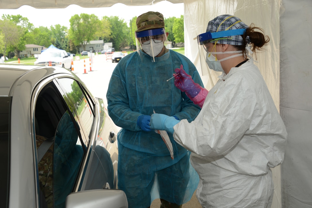 Two people in medical uniforms stand next to each other.