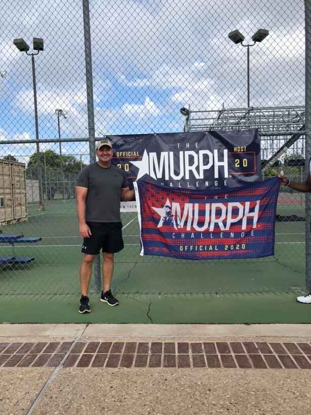 U.S. Air Force Col. Robert Ramirez, 17th Training Wing vice commander, holds The Murph Challenge flag after completing The Murph Challenge at the Mathis Fitness Center on Goodfellow Air Force Base, Texas, May 25, 2020. 17th Training wing leadership paid their respects to U.S. Navy Lt. Michael P. Murphy by partaking in the challenge. (Courtesy photo)