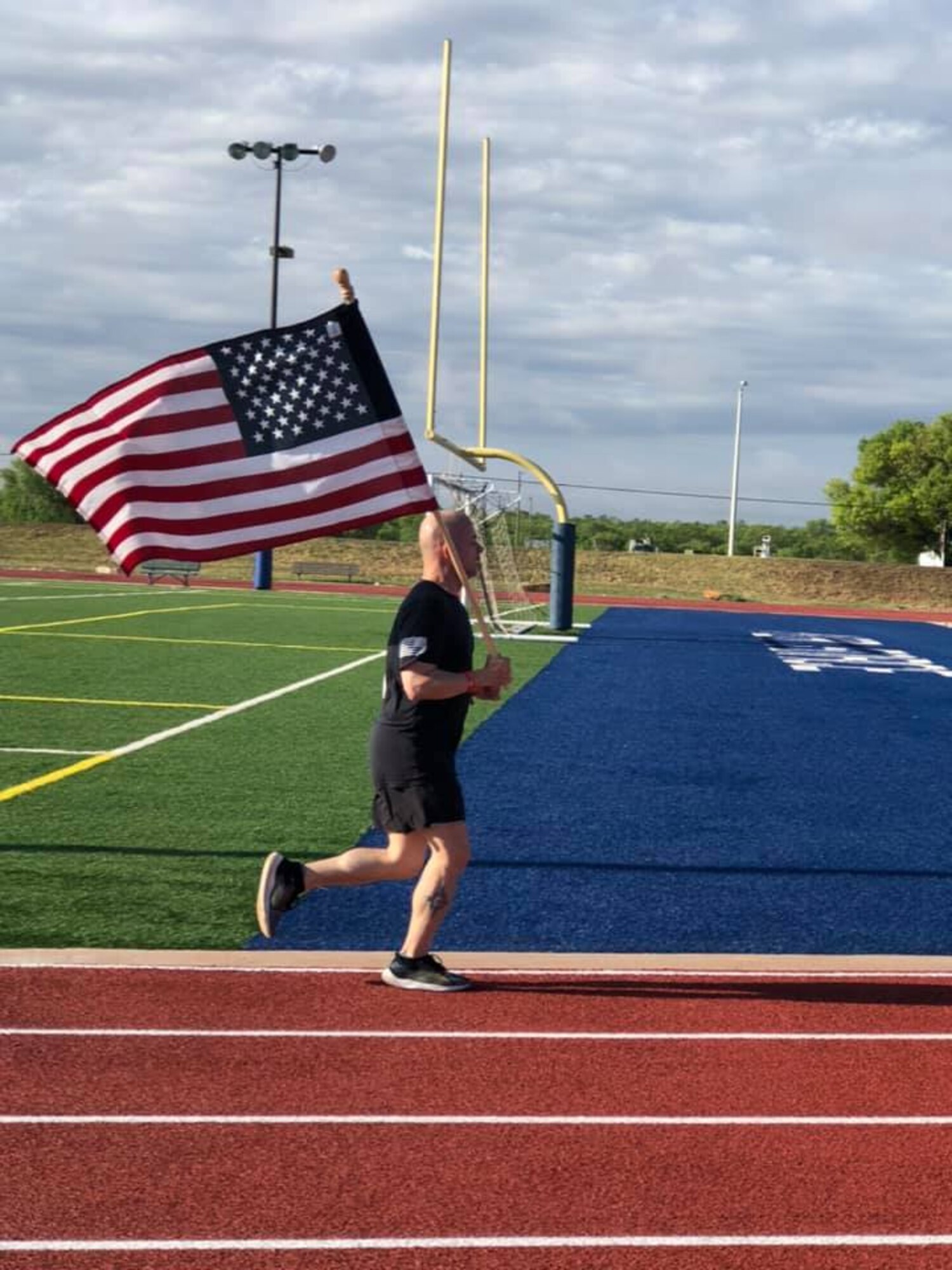 U.S. Air Force Col. Andres Nazario, 17th Training Wing commander, runs on the track behind the Mathis Fitness Center during The Murph Challenge, on Goodfellow Air Force Base, Texas, May 25, 2020. The challenge consisted of a one-mile run followed by 100 pull-ups, 200 push-ups, 300 air squats, and finished with a one-mile run, all while wearing a 20-pound vest. (Courtesy photo)