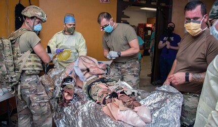 Members of the 555th Forward Surgical Team assess a simulated patient