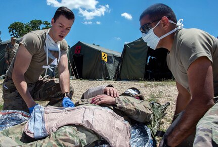 Members of the 555th Forward Surgical Team assess a simulated combat casualty