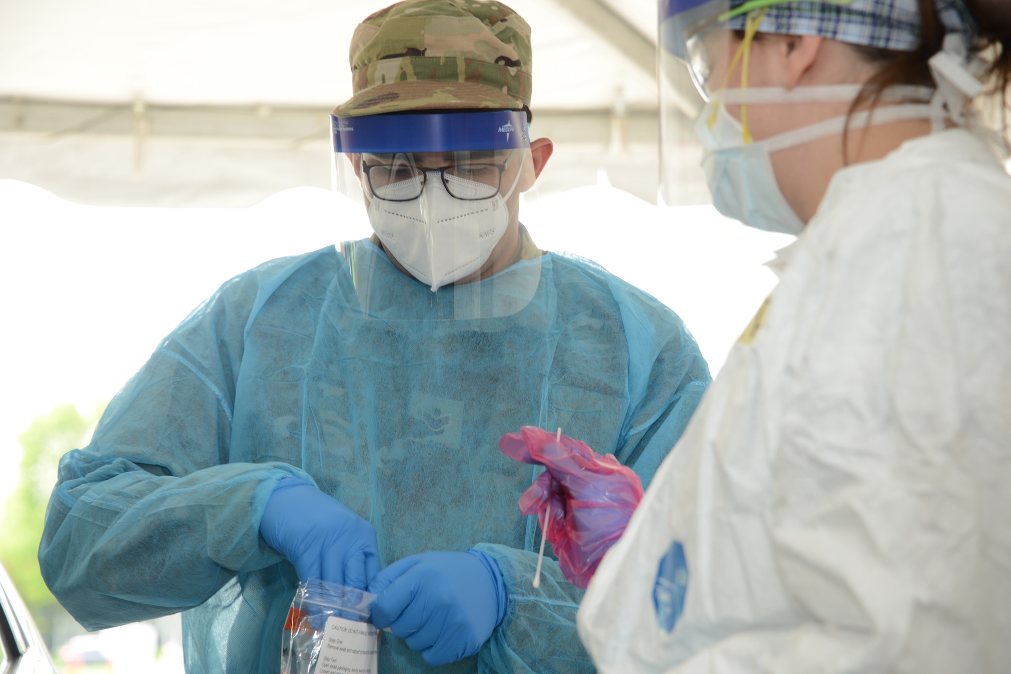 Iowa Air National Guard Senior Airman Manuel Zertuche, a 185th Air Refueling Wing medical technician, works with medical staff to administer a COVID-19 test at the Sioux Center, Iowa, “TestIowa” site May 27, 2020.
