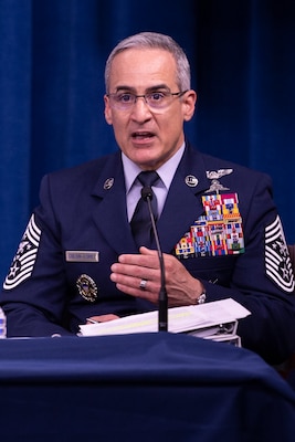 A man in uniform speaks into a microphone.