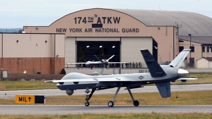 MQ-9 Reaper sits on runway in front of hangar