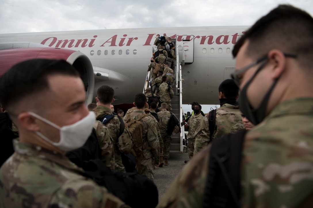 Airmen board an aircraft for a deployment.