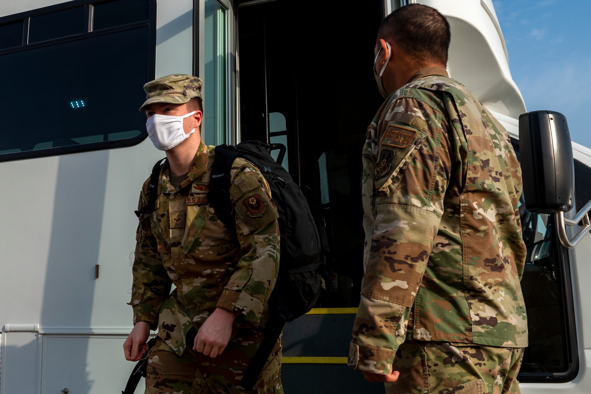 A prior-quarantined Airman exits a bus to in-process with the 386th Expeditionary Force Support Squadron Personnel Support for Contingency Operations center at Ali Al Salem Air Base, Kuwait, May 25, 2020. PERSCO is strictly a deployed environment function and is a vital task to ensure proper accountability takes place within the AOR. (U.S. Air Force photo by Senior Airman JaNae Capuno)
