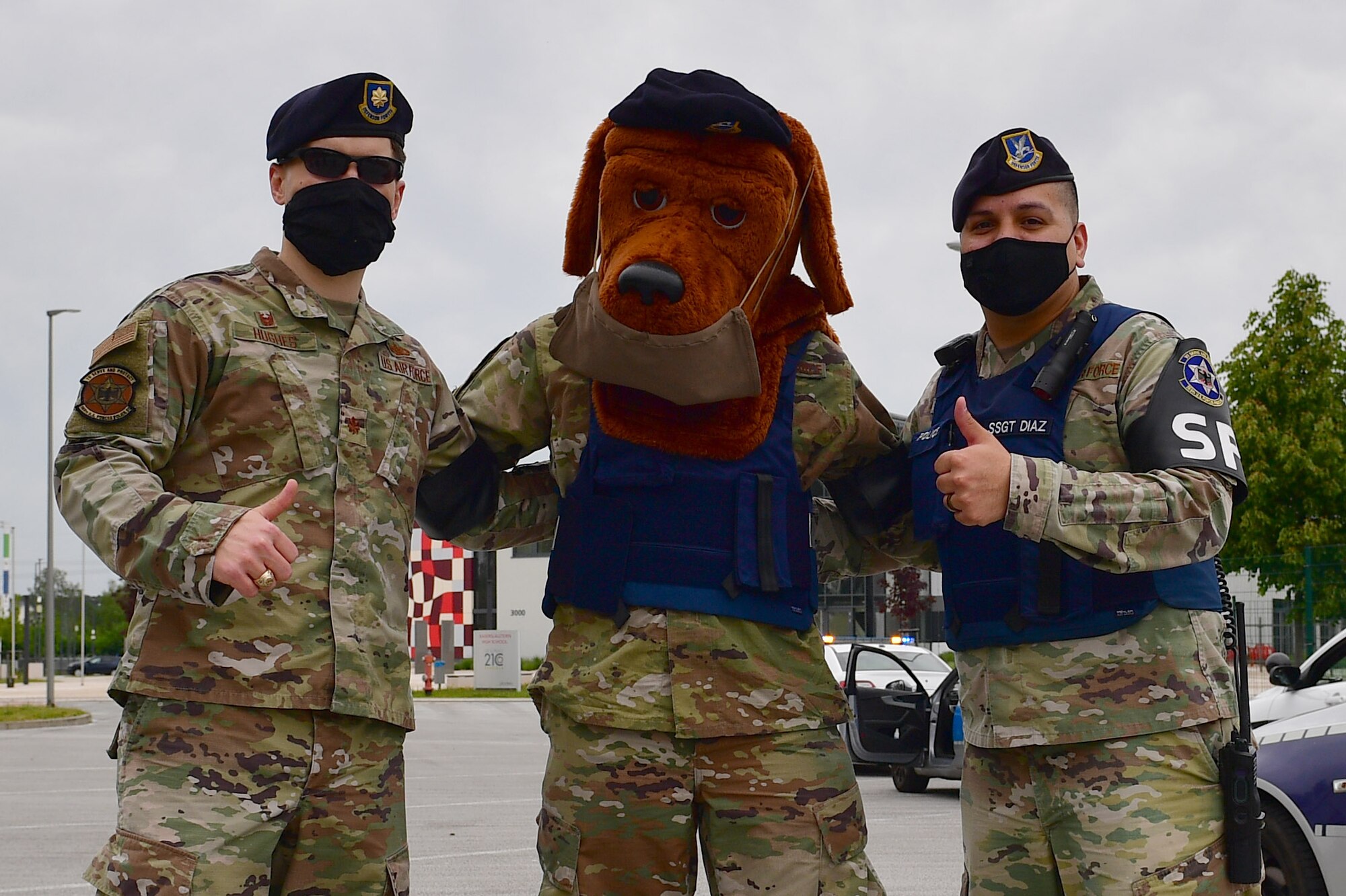 Two Airmen stand with McGruff the Crime Dog.