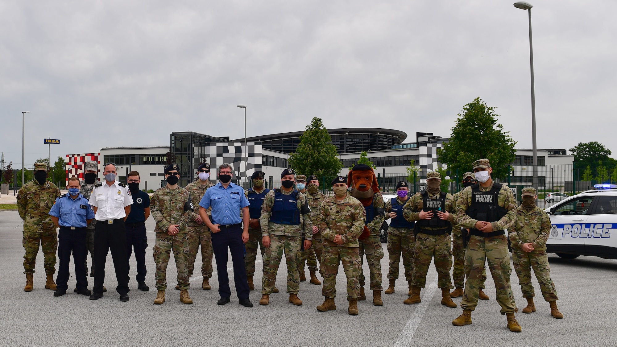 A large group of first responders stand in a parking lot.