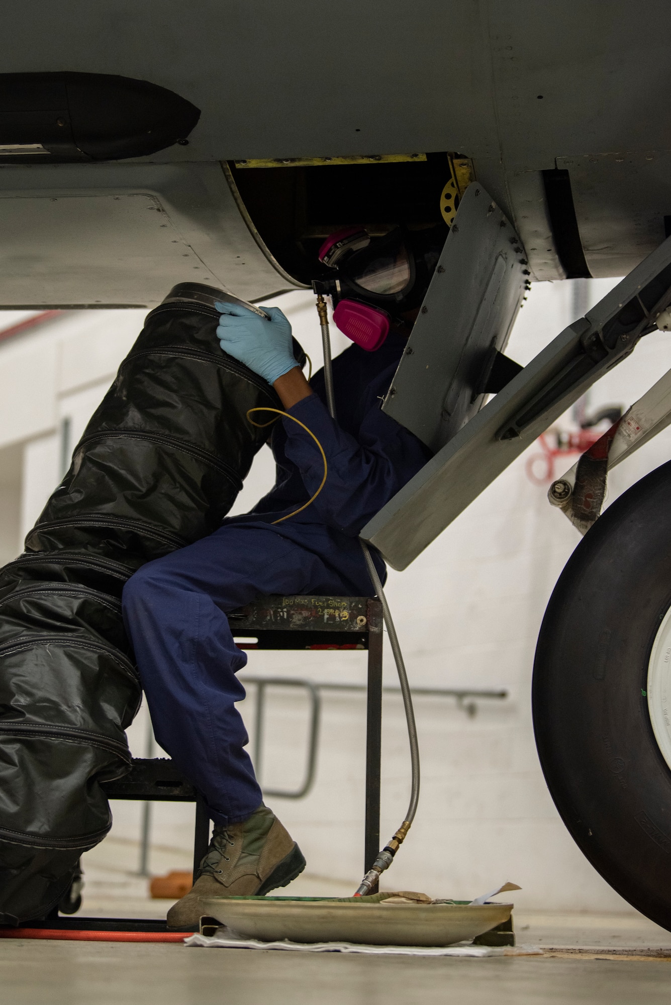 Airman 1st Class Dezmond Ross, 100th Maintenance Squadron fuel systems repair apprentice, brings an air duct to the opening of a KC-135 Stratotanker at RAF Mildenhall, England, May 27, 2020. The air duct pushes fresh air into the interior fuel cells to provide ventilation and decrease the concentration of fuel vapor. (U.S. Air Force photo by Airman 1st Class Joseph Barron)