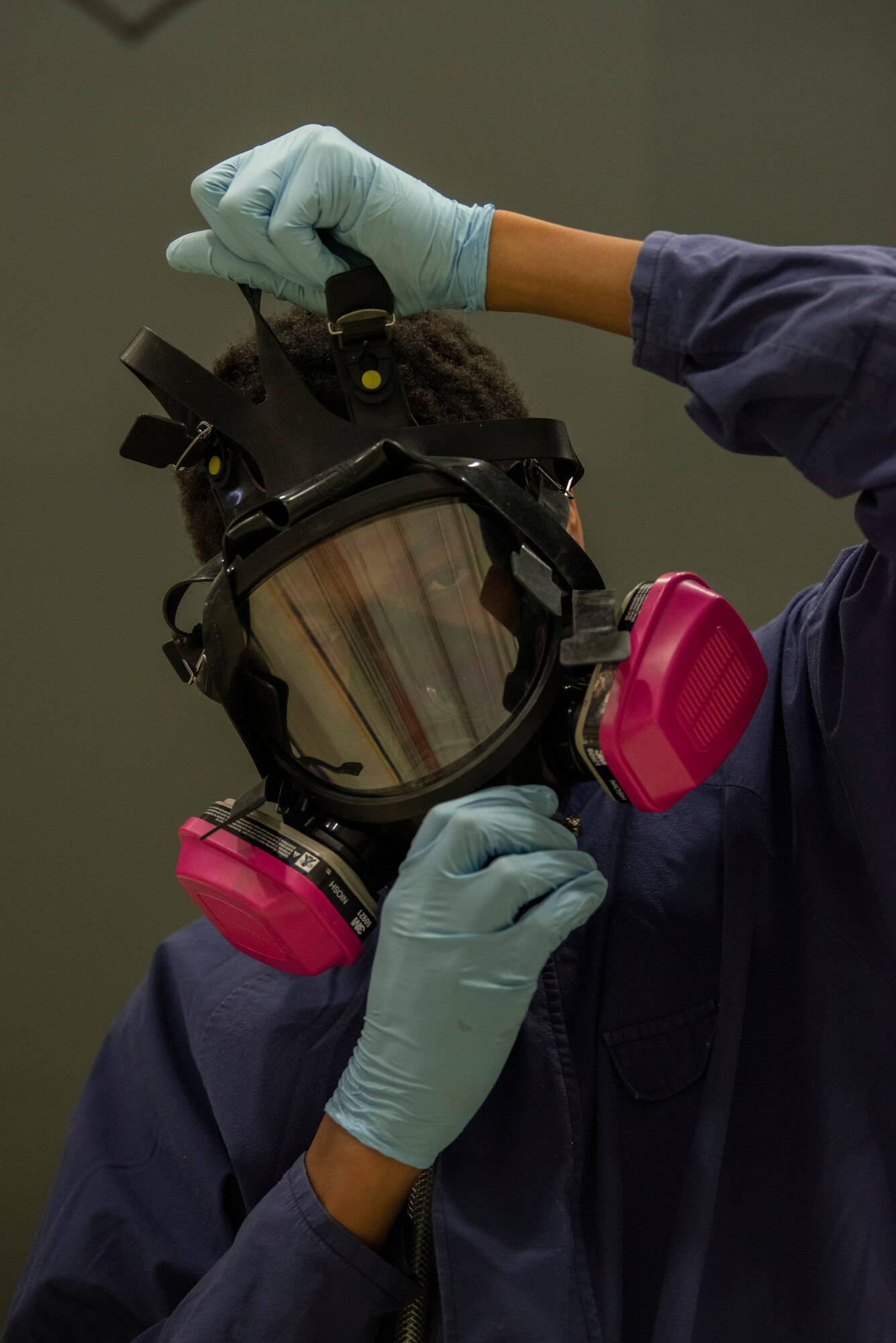 Airman 1st Class Dezmond Ross, 100th Maintenance Squadron fuel systems repair apprentice, puts on an oxygen respirator at RAF Mildenhall, England, May 27, 2020. Fuel systems Airmen wear the respirator to protect themselves from the vapor while cleaning inside the fuel cells of aircraft. (U.S. Air Force photo by Airman 1st Class Joseph Barron)
