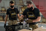 Spc. Ross Schlichting, left, and Staff Sgt. Vernon Long, with the 1221st Transport Company, Missouri National Guard, pack school lunches for delivery April 27, 2020, at Osage County R-II School, Linn, Missouri. Nearly 200 Guardsmen are assisting schools with distribution and delivery of food to students in communities across the state as part of the state’s response to the COVID-19 pandemic.