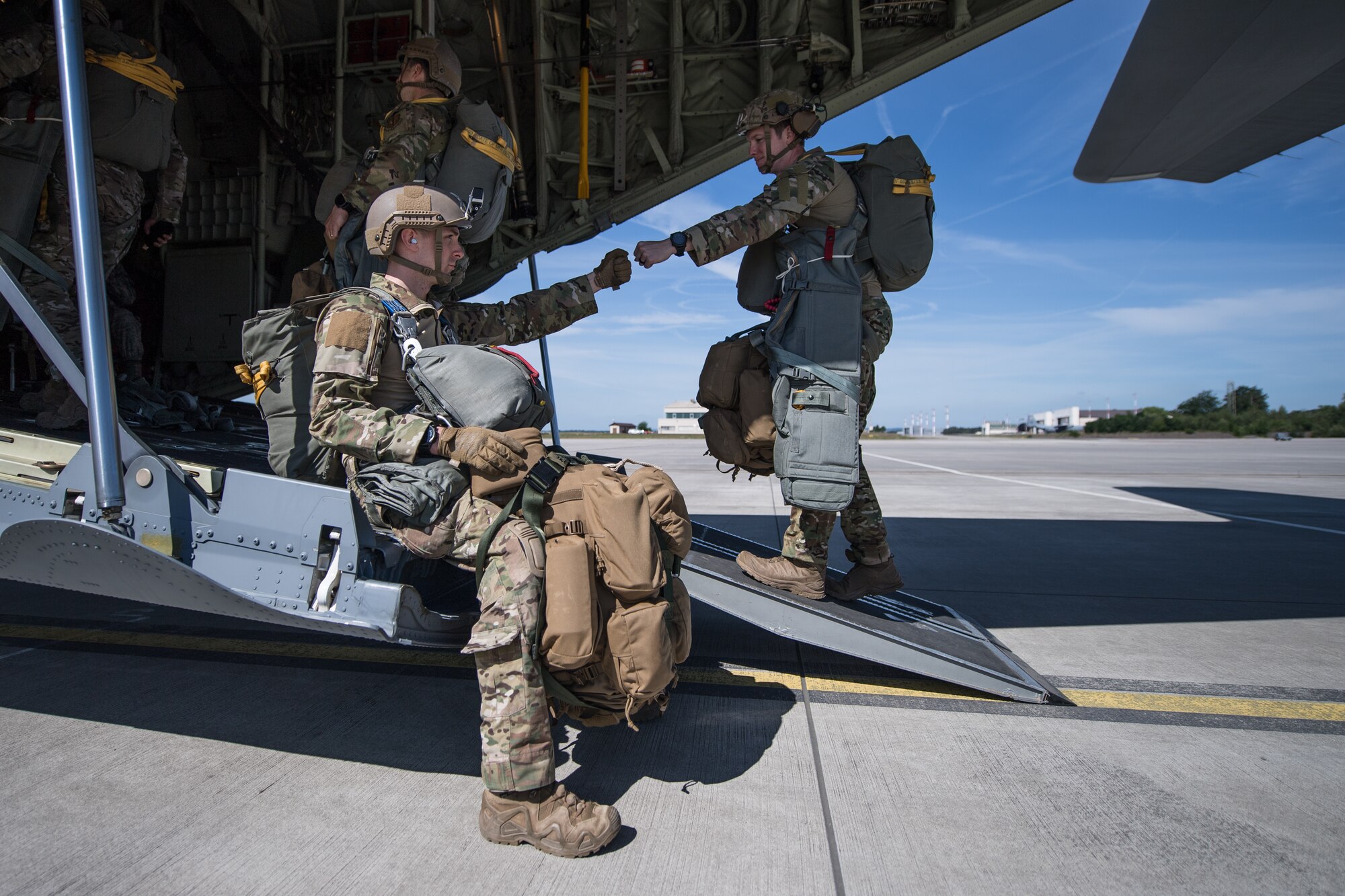 Photo of Airmen bumping fists while boarding an aircraft