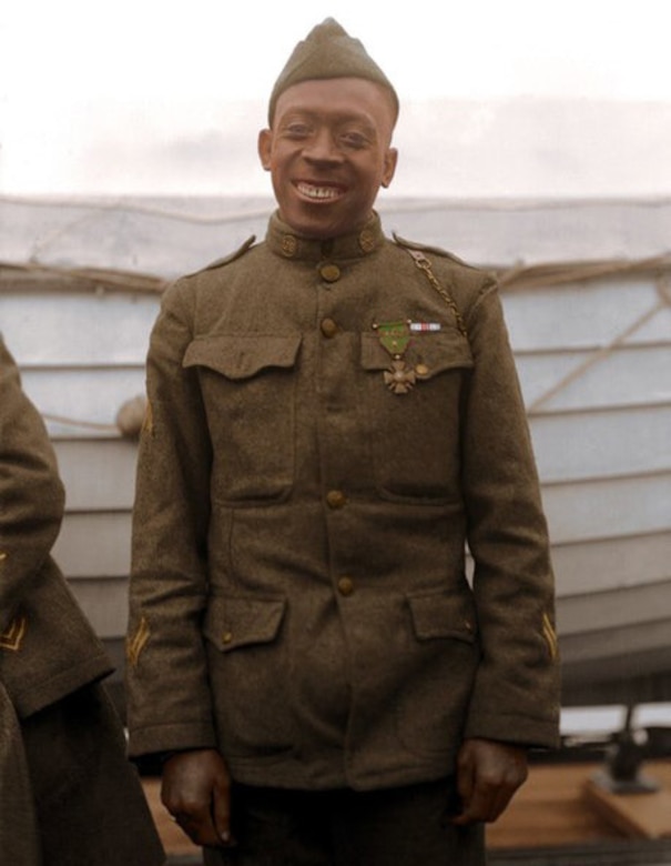 A man in a military uniform smiles for the camera.