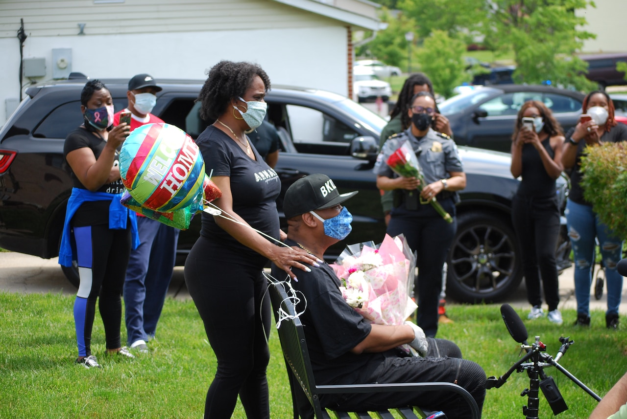 A woman pushes a man in a wheelchair.