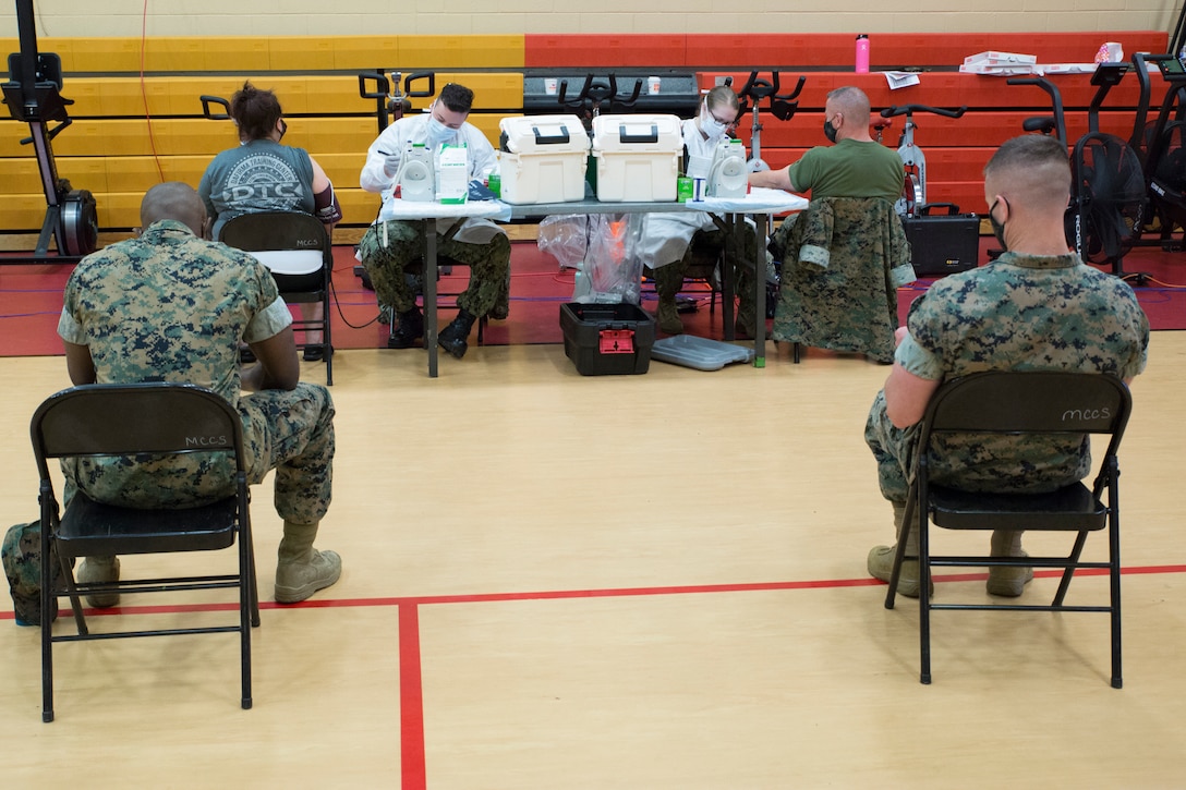 Patrons wait to have their vitals checked during an Armed Services Blood Program (ASBP) blood drive at Hopkins Gymnasium on Camp Elmore, Norfolk, Virginia, May 28, 2020. Despite the Coronavirus Disease 2019 (COVID-19) pandemic, ASBP and leaders with Headquarters Service Battalion, U.S. Marine Corps Forces Command, Fleet Marine Force Atlantic, coordinated this event to help support the ASBP in their critical mission of blood collection, manufacturing and transfusion of the U.S. military. Patrons waiting to donate blood were seated six feet apart for safety, and wore masks throughout their time in the gym. To donate or get more information about donating during COVID-19 visit https://www.militaryblood.dod.mil/. (U.S. Marine Corps Photo by Sgt. Danielle R. Prentice)