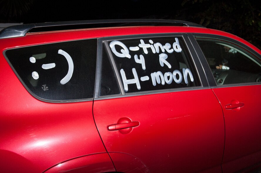 The newlyweds' red getaway car is adorned with a fun message that says Q-tined 4 R H-Moon after their wedding in Sumter, South Carolina.