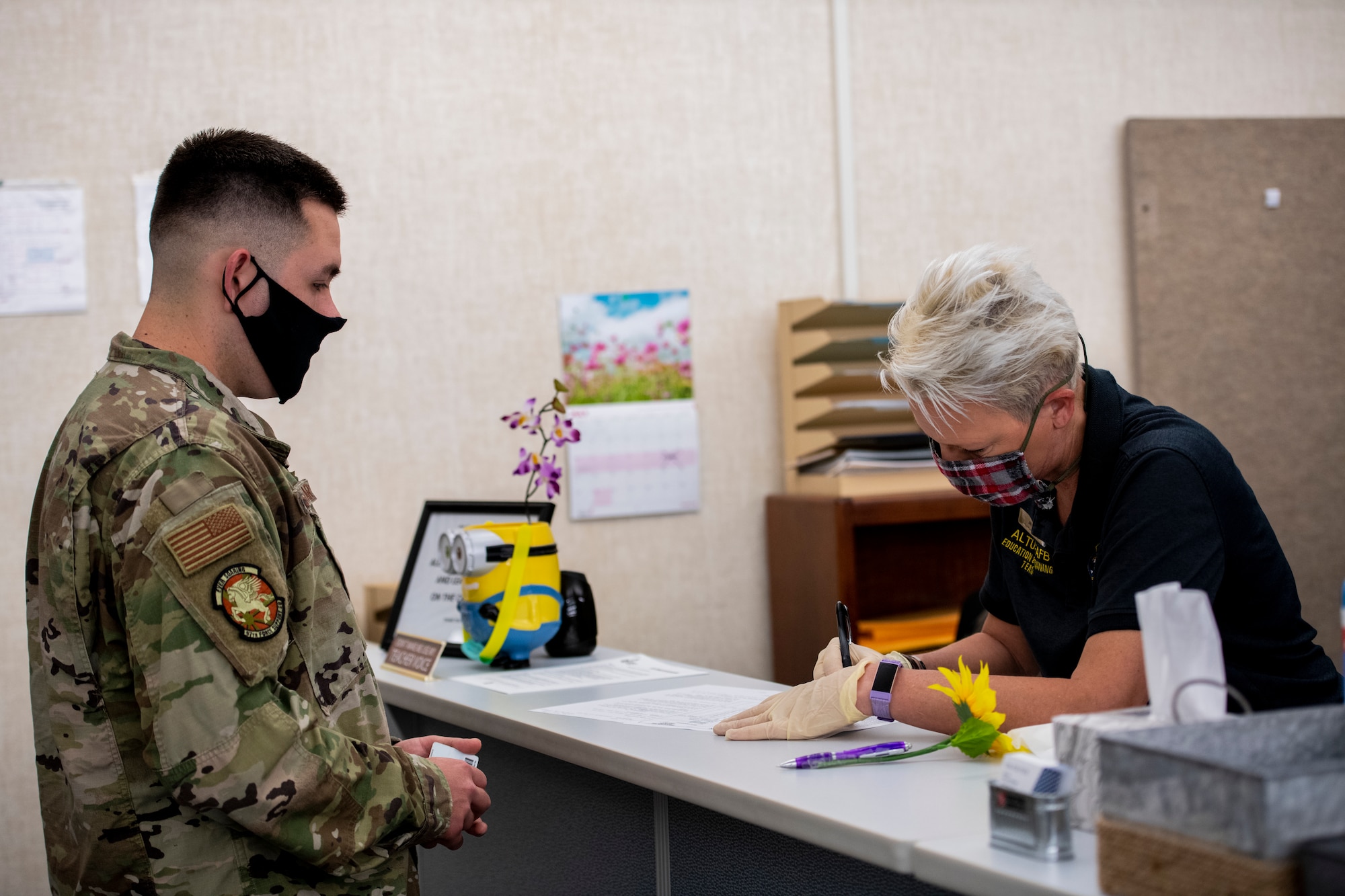 U.S. Air Force Senior Airman Cody Cashdollar, assigned to the 97th Force Support Squadron, signs in for promotion testing with Jill Coles, the test control manager assigned to the 97th FSS education center, May 20, 2020 at Altus Air Force Base, Oklahoma.