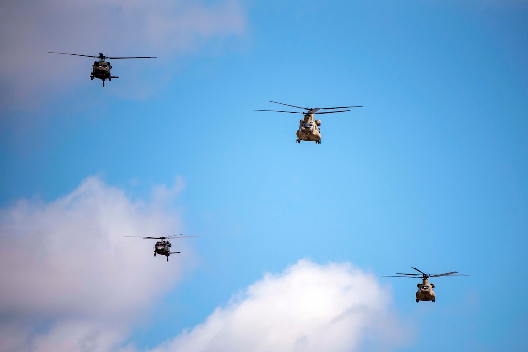 Four Army helicopters fly near one another.