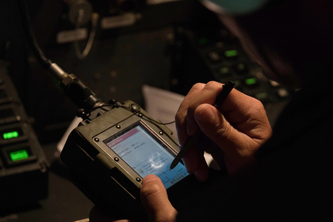 Airman enters data on an electronic device
