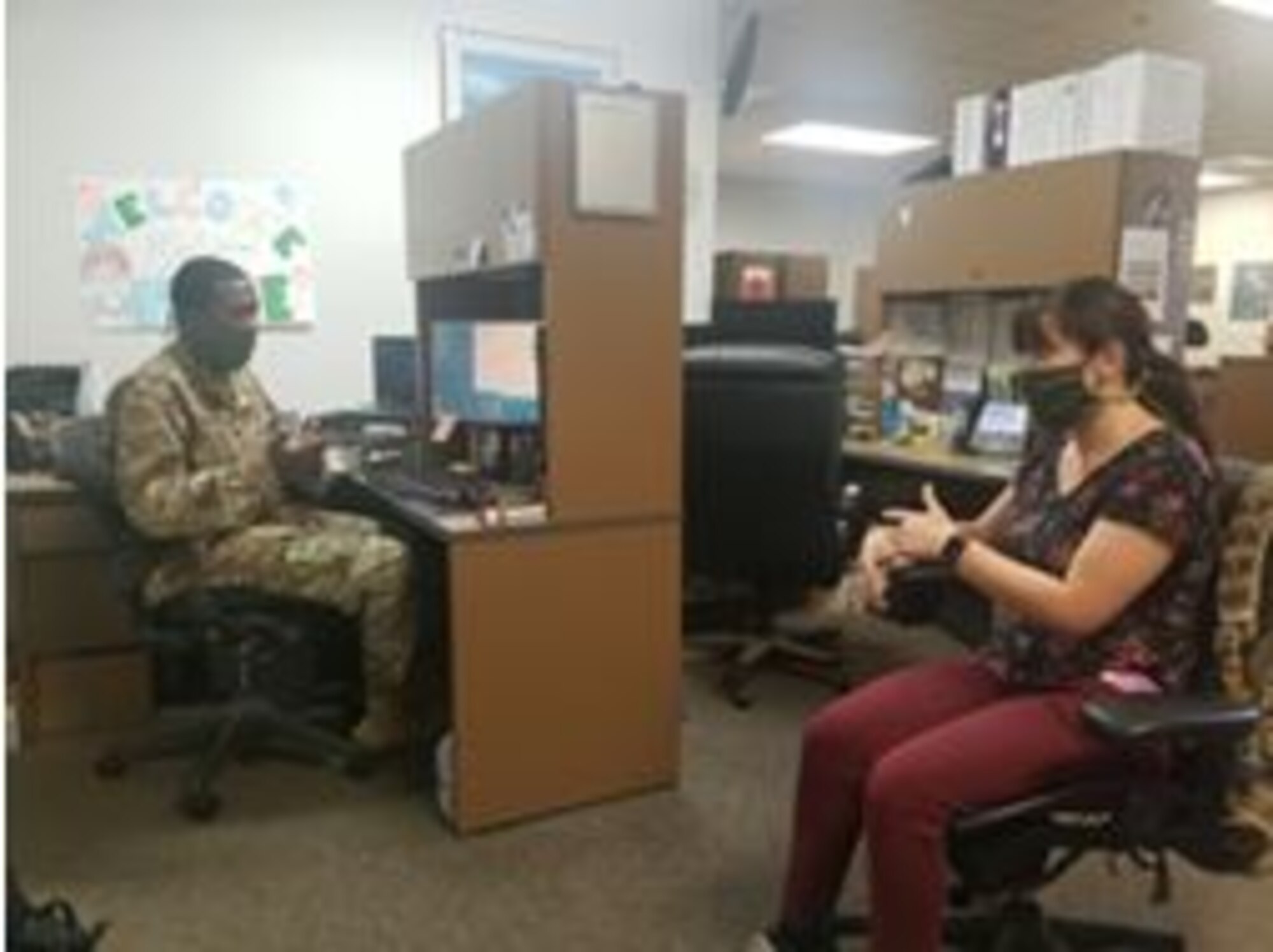 Master Sgt. Richard Fulcher and contractor Leeann Schunke, 452nd Communications Squadron, maintain six feet of separation while working together during the COVID-19 pandemic.