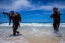U.S. Marines with Lima Company, 3rd Battalion, 3d Marine Regiment, traverse through water during an amphibious assault exercise, Marine Corps Base Hawaii, May 28, 2020. Bravo Company, 1st Battalion, 3d Marine Regiment, and Lima Company, 3rd Battalion, 3d Marine Regiment, conducted an amphibious assault exercise and military operations in urban terrain to increase littoral mobility proficiency in 3d Marine Regiment and advance the goals of the Commandant of the Marine Corps 2030 Force Design. (U.S. Marine Corps photo by Cpl. Matthew Kirk)