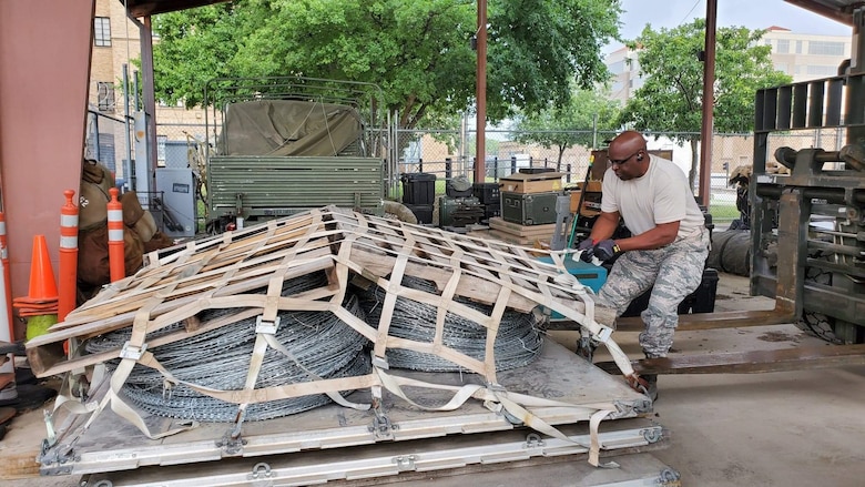 Tech. Sgt.  Ronald Hairston, a ground transportation operator with the 26th Aerial Port Squadron at Joint Base San Antonio-Lackland, Texas, secures concertina wire in preparation for shipping to the U.S. Army on May 22, 2020.