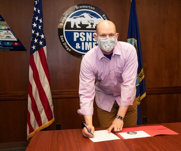 Members of the Puget Sound Naval Shipyard & Intermediate Maintenance Facility Safety Executive Steering Committee sign a document formalizing the establishment of the PSNS & IMF Safety Management System. The PSNS & IMF Safety Management System is a result of new Navy requirements for the establishment of a centralized safety program that consolidates the management of the shipyard’s safety culture in one location.