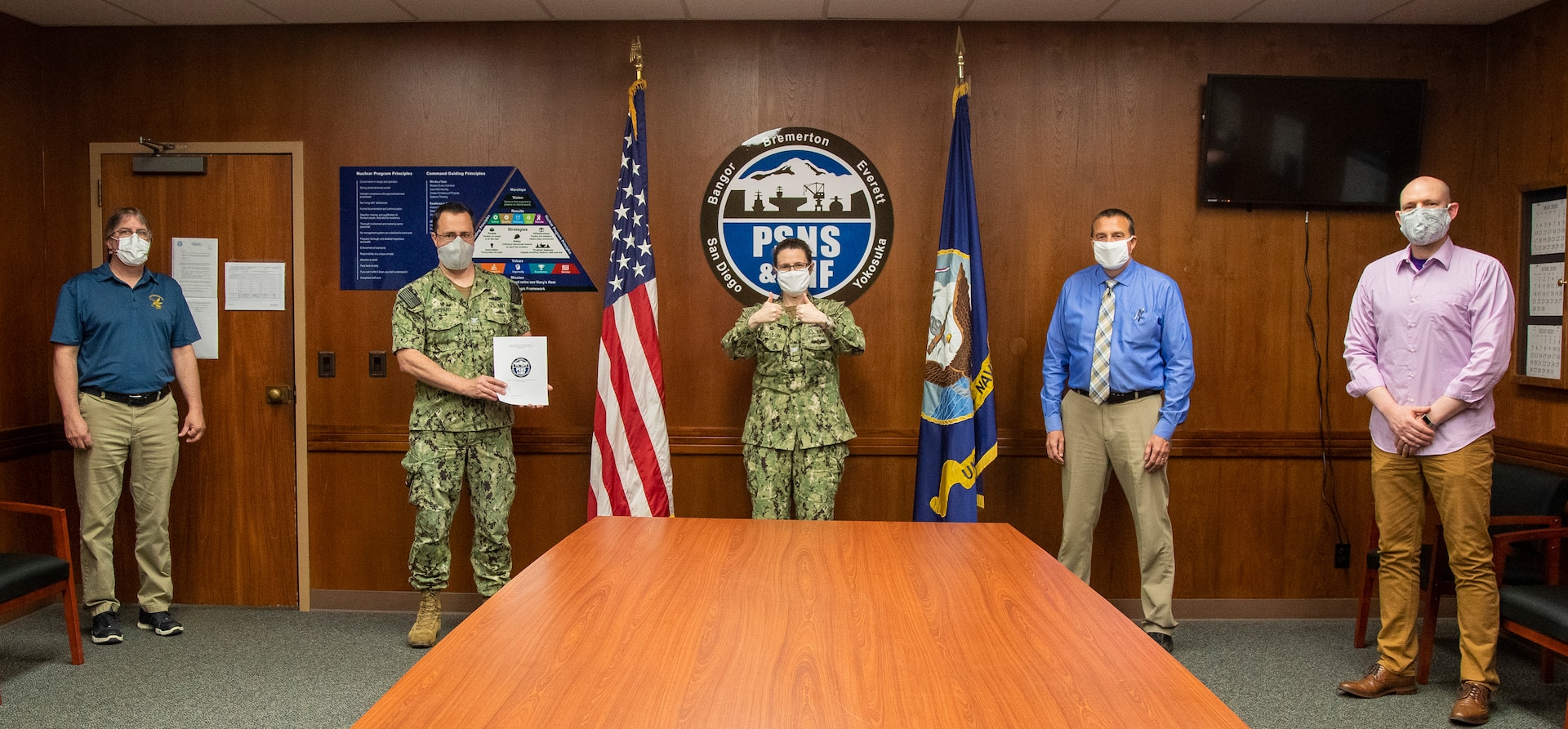 Members of the Puget Sound Naval Shipyard & Intermediate Maintenance Facility Safety Executive Steering Committee celebrate signing a document establishing the PSNS & IMF Safety Management System. The PSNS & IMF Safety Management System is a result of new Navy requirements for the establishment of a centralized safety program that consolidates the management of the shipyard’s safety culture in one location.