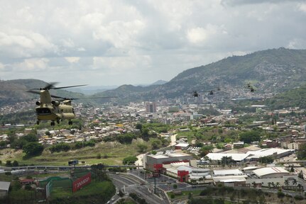 U.S. Army aircraft assigned to the 1st Battalion, 228th Aviation Regiment fly over a metropolitan area in the skies of Central America during a 10-aircraft formation exercise.