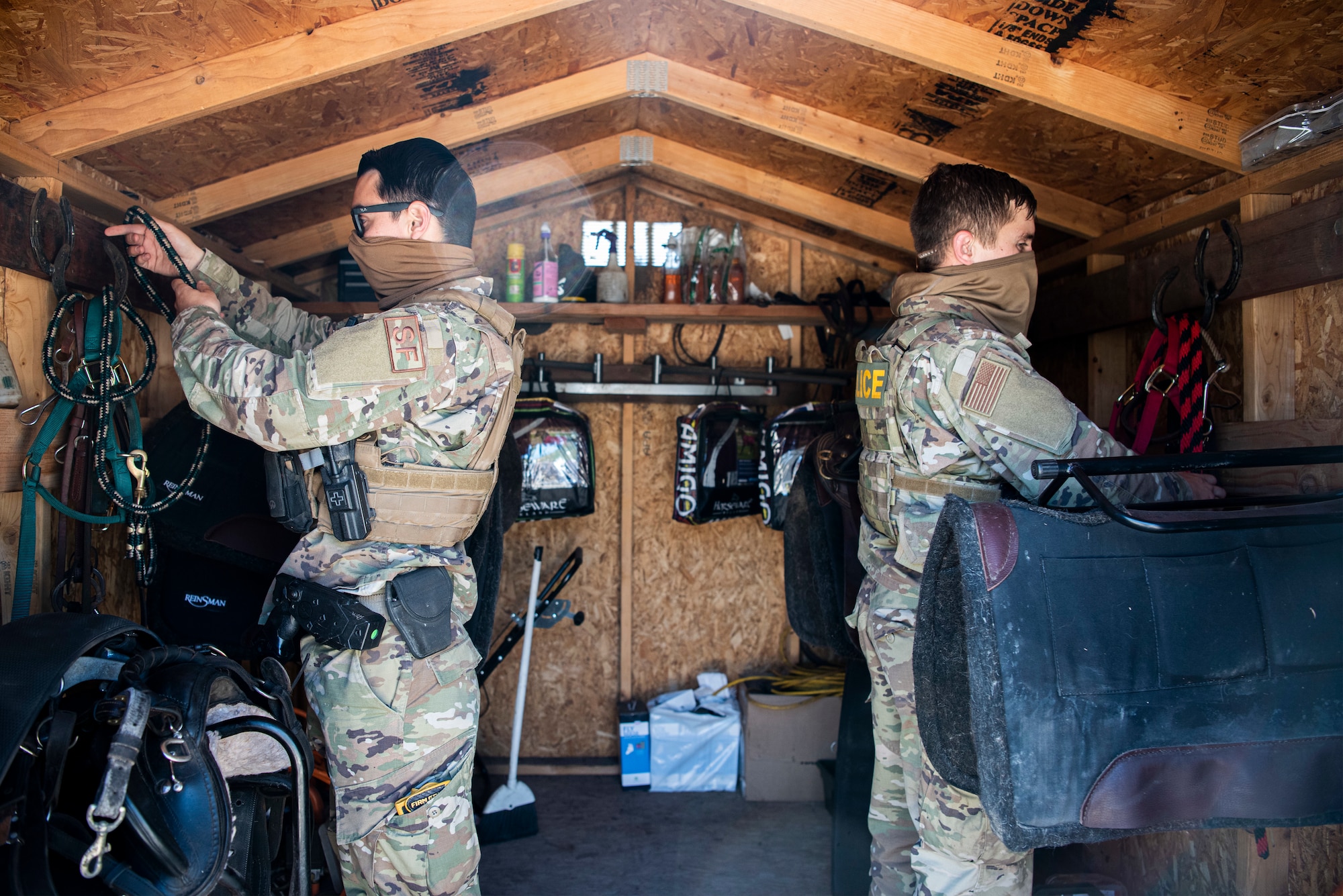 Senior Airman Zachary Contreras and Airman 1st Class Kyle Young, 30th Security Forces Squadron temporary conservation patrolmen, put away equipment after a horse patrol May 20, 2020, at Vandenberg Air Force Base, Calif. During the COVID-19 pandemic, Vandenberg’s conservation unit has increased their hours and workload in order to keep up with the influx of people participating in recreational activities across the installation. Along with installation beaches, the unit patrols public beaches, which potentially increases their exposure to those not wearing masks, which is a current base requirement. (U.S. Air Force photo by Senior Airman Hanah Abercrombie)