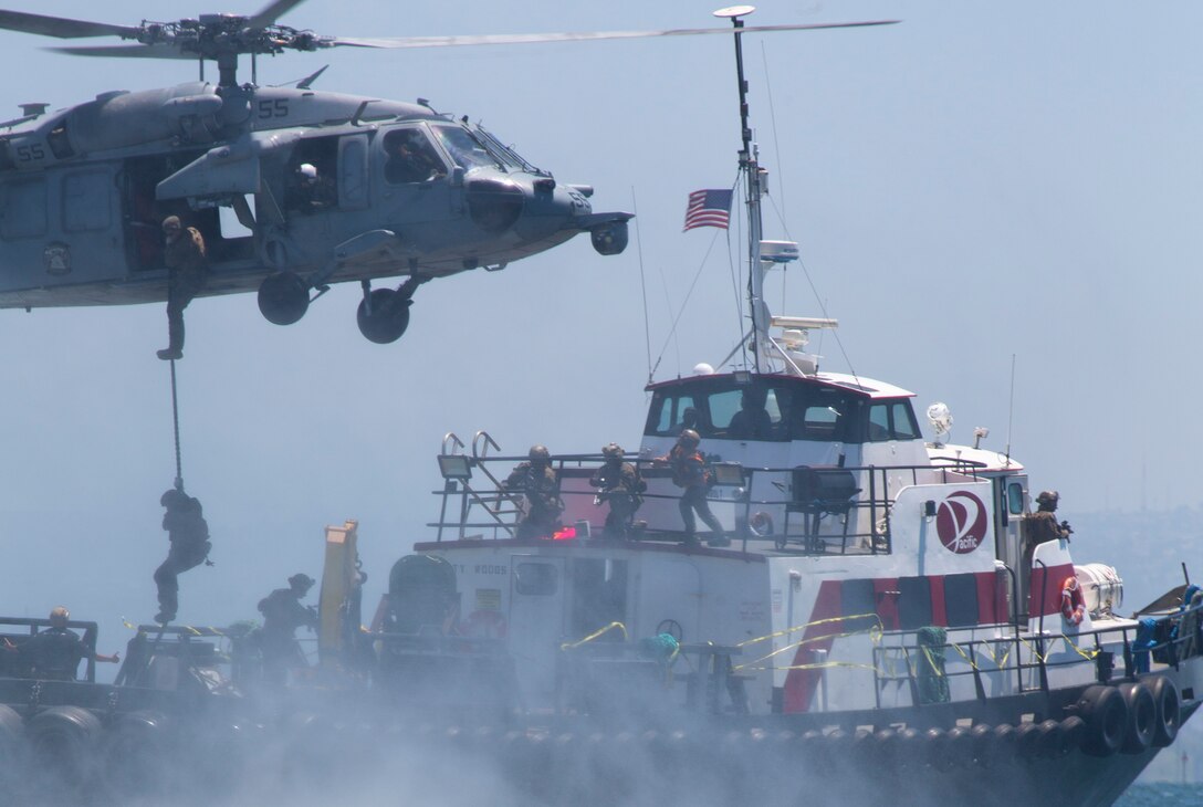 U.S. Marines with All-Domain Reconnaissance Detachment, 15th Marine Expeditionary Unit, fast-rope from a U.S. Navy MH-60S Seahawk helicopter with Helicopter Sea Combat (HSC) Squadron 23 during a visit, board, search and seizure drill at Naval Amphibious Base Coronado, California, May 21, 2020. The ADR Detachment conducted visit, board, search and seizure drills as the culminating event of a two-week Maritime Interoperability Course, designed to enhance participants’ techniques for boarding and taking over vessels in preparation for an upcoming deployment. (U.S. Marine Corps photo by Sgt. Desiree King)
