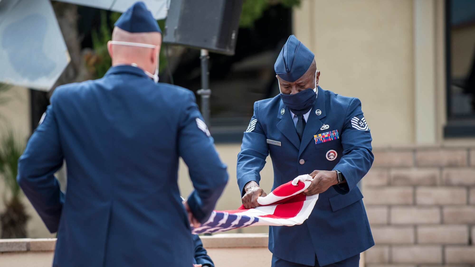Air Force color guard members fold a flag before presenting it to Col. Christopher Spinelli during his retirement ceremony at Edwards Air Force Base, California, May 29. Spinelli retired from the Air Force after more than 24 years of service and plans to head back home to Texas. (Air Force photo by Giancarlo Casem)
