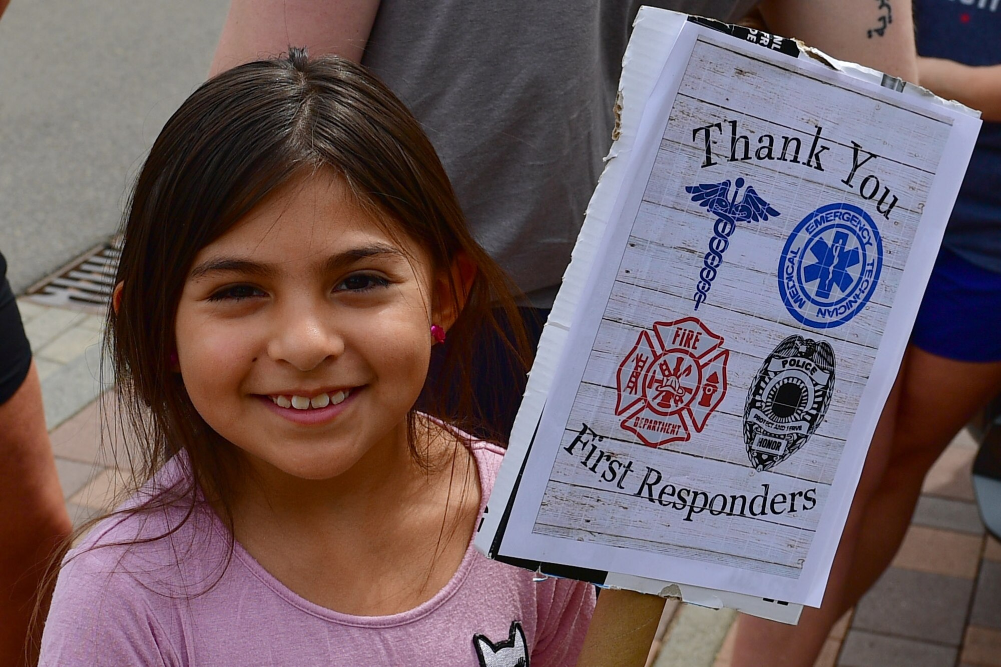 A child holds a thank you sign.