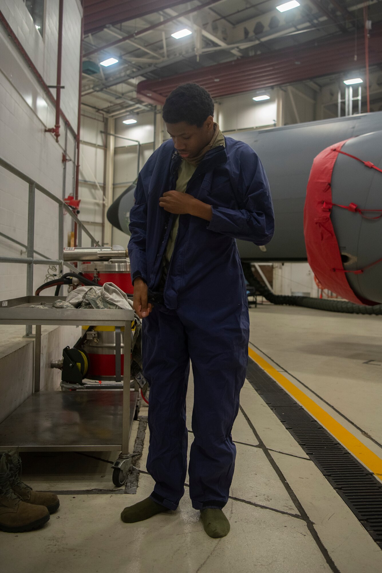 Airman 1st Class Dezmond Ross, 100th Maintenance Squadron fuel systems repair apprentice, puts on his static-resistant suit at RAF Mildenhall, England, May 27, 2020. The suit is worn inside fuel cells to protect Airmen from hazardous materials and to limit the creation of static electricity in an environment containing fuel vapor. (U.S. Air Force photo by Airman 1st Class Joseph Barron)