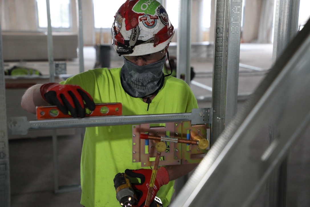 A contractor eyes the levelness of his work May 11, on the framework for the pods of what will be an alternate care facility in the fight against the Covid-19 pandemic in Kalispell, Mont. The state of Montana requested FEMA to task the U.S. Army Corps of Engineers, Omaha District, to build the ACF on the vacant, undeveloped, third floor of Montana Children’s, the new pediatric facility of the Kalispell Regional Medical Center. The temporary facility would accommodate non-acute patients in case Montana faces an increase in COVID-19 patients in the fall. When completed, the ACF will have 98 patient care rooms, seven nurses' stations, four restrooms, three pharmacies and a medical supply storage room.