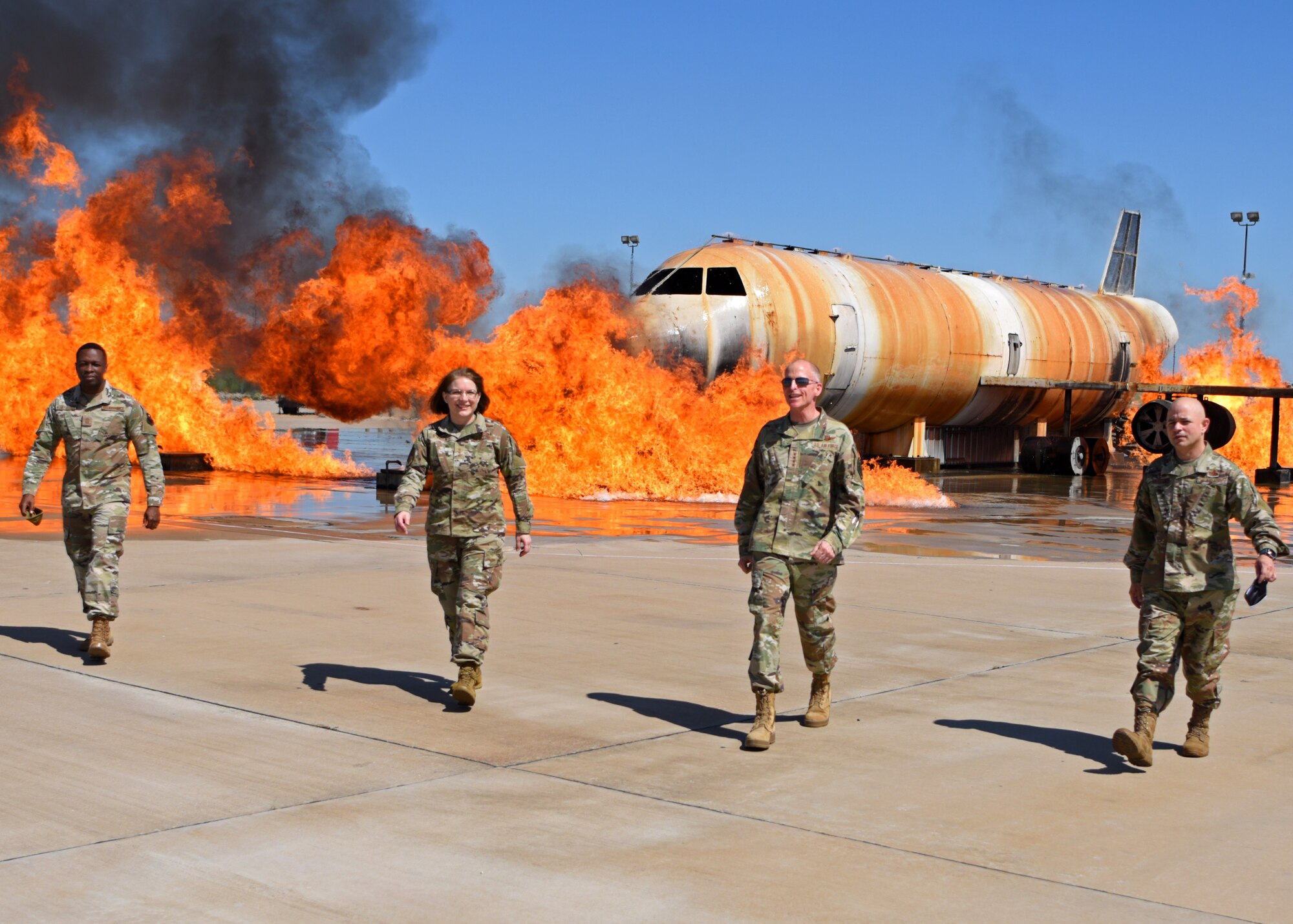 U.S. Air Force Chief Master Sgt. Lavor Kirkpatrick, 17th Training Wing command chief, Lt. Gen. Mary O’Brien, deputy chief for intelligence surveillance and reconnaissance, Gen. Stephen W. Wilson, vice chief of staff of the Air Force, and Col. Andres Nazario, 17th TRW commander, walk away from a fire training plane at the Louis F. Garland Department of Defense Fire Academy on Goodfellow Air Force Base, Texas, May 29, 2020. Wilson and O’Brien put out the fire around the plane with a truck-mounted, water hose. (U.S. Air Force photo by Airman 1st Class Ethan Sherwood)