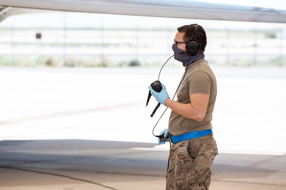 Senior Airman Gilbert Reyes-Camacho, 412th Aircraft Maintenance Squadron, talks to an F-22 Raptor pilot prior to takeoff following an operational rapid crew swap at Edwards Air Force Base, California, April 30. (Photo courtesy of Kyle Larson/Lockheed-Martin)