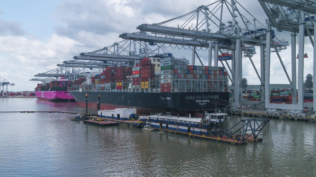 The Dredge Hampton Roads is shown maintaining a deepened channel in front of large cargo vessels docked at the Garden City Terminal of the Georgia Ports Authority, May 28, 2020. Photo by Georgia Ports Authority