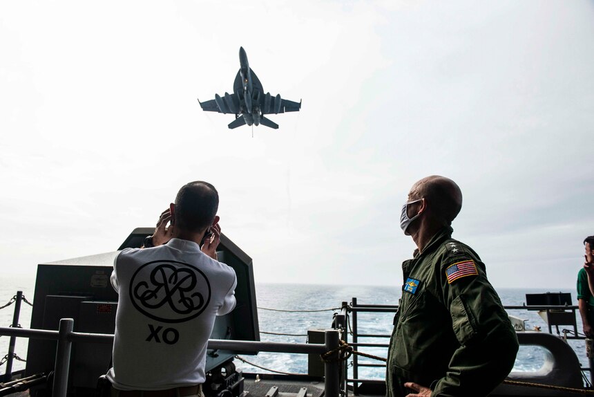 PHILIPPINE SEA (May 30, 2020) Commander, U.S. 7th Fleet, Vice Adm. William R. Merz and Capt. Matthew Ventimiglia, executive officer of the Navy’s only forward-deployed aircraft carrier USS Ronald Reagan (CVN 76), watch an F/A-18F Super Hornet, attached to Strike Fighter Squadron (VFA) 102, approach the flight deck during a scheduled visit. During the visit, Merz talked with Sailors about the health of the force and observed the ship’s operational readiness. Ronald Reagan, the flagship of Carrier Strike Group 5, provides a combat-ready force that protects and defends the United States, as well as the collective maritime interests of its allies and partners in the Indo-Pacific region.