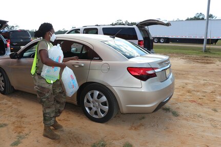 U.S. Army Spc. Alexis Jacobs of the 859th Vertical Engineer Company, 890th Engineer Battalion, Mississippi Army National Guard, loads ice into a Hancock County resident's car in Kiln, Miss., Oct. 31, 2020. Guard members were assisting state and local emergency officials with Hurricane Zeta recovery efforts.