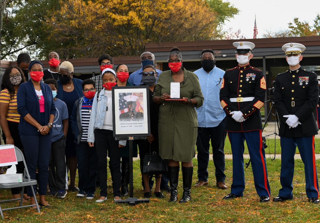 U.S. service members with 4th Combat Engineer Battalion stand beside Lance Cpl. Corey Staten’s photo and family members after the completion of his posthumous award ceremony in Baltimore, Oct. 24, 2020.