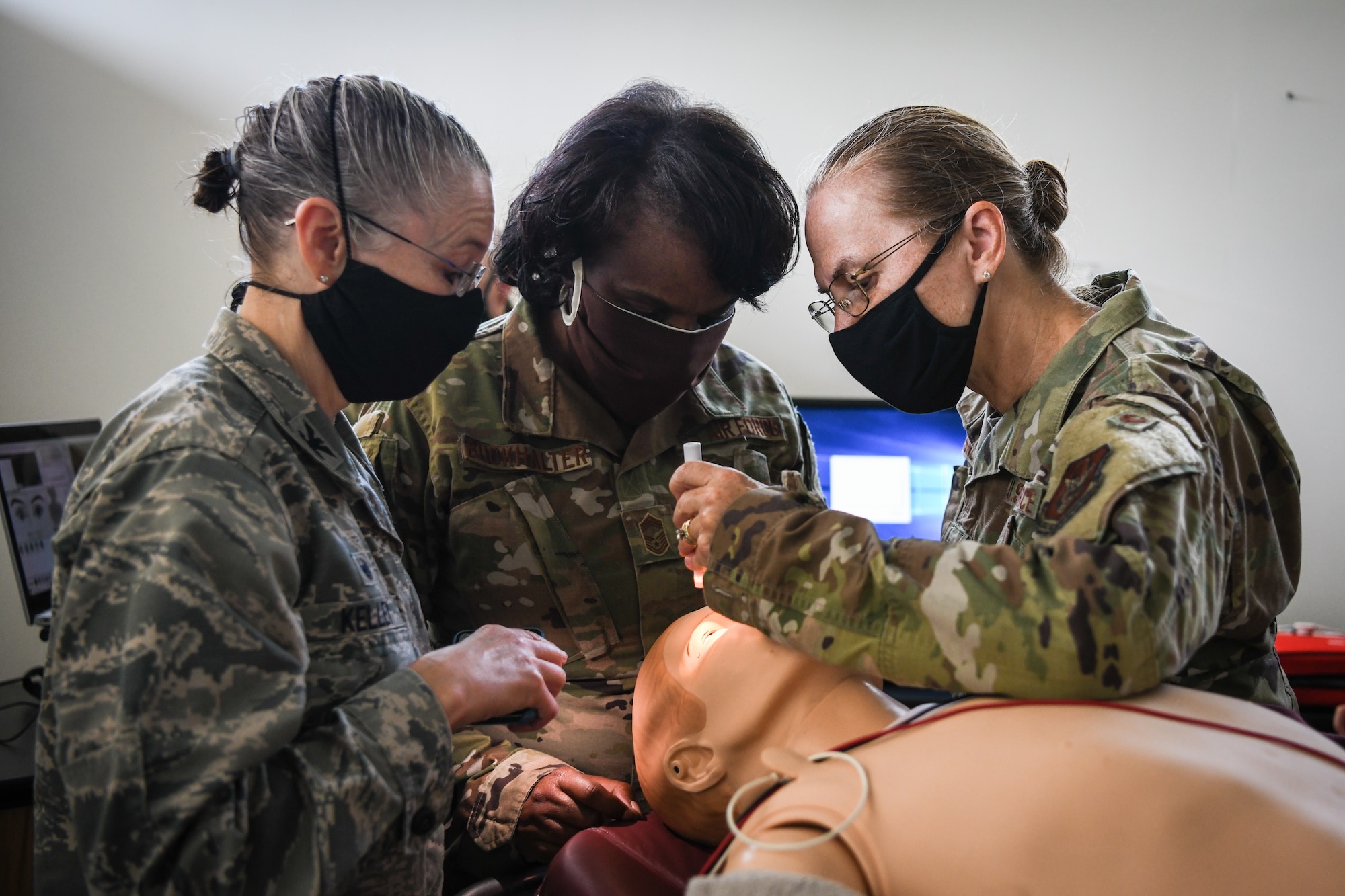 Col. Colleen E. Kelley, 910th Medical Squadron Commander, Col. Teresa Bisnett, Air Force Reserve Command surgeon general, and Chief Master Sgt. Regina Buckhalter, ARFC chief medical enlisted force manager, check the pupils of a trauma SimMan Sept. 12, 2020, at the 910th Medical Squadron building at Youngstown Air Reserve Station.