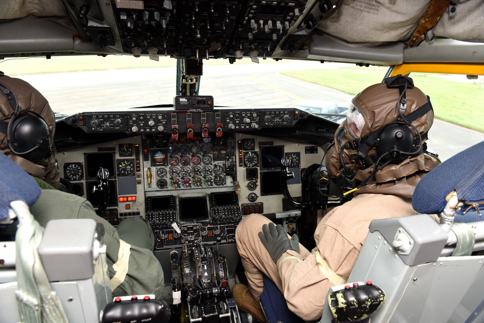 U.S. Air Force Capt. Rory Montgomery, left, 351st Air Refueling Squadron aircraft commander, and Capt. Daylon Roitsch, 351st ARS pilot, wear aircrew eye and respiratory protection equipment while simulating preflight checks in a KC-135 Stratotanker aircraft during a chemical, biological, radiological and nuclear exercise at Royal Air Force Mildenhall, England, Oct. 28, 2020. The aircrew and crew chiefs tested an innovative headset, which uses the bones in the user’s ear to transmit sound waves, to test its capabilities while being worn with AERP equipment and mission-oriented protective posture gear. (U.S. Air Force photo by Karen Abeyasekere)