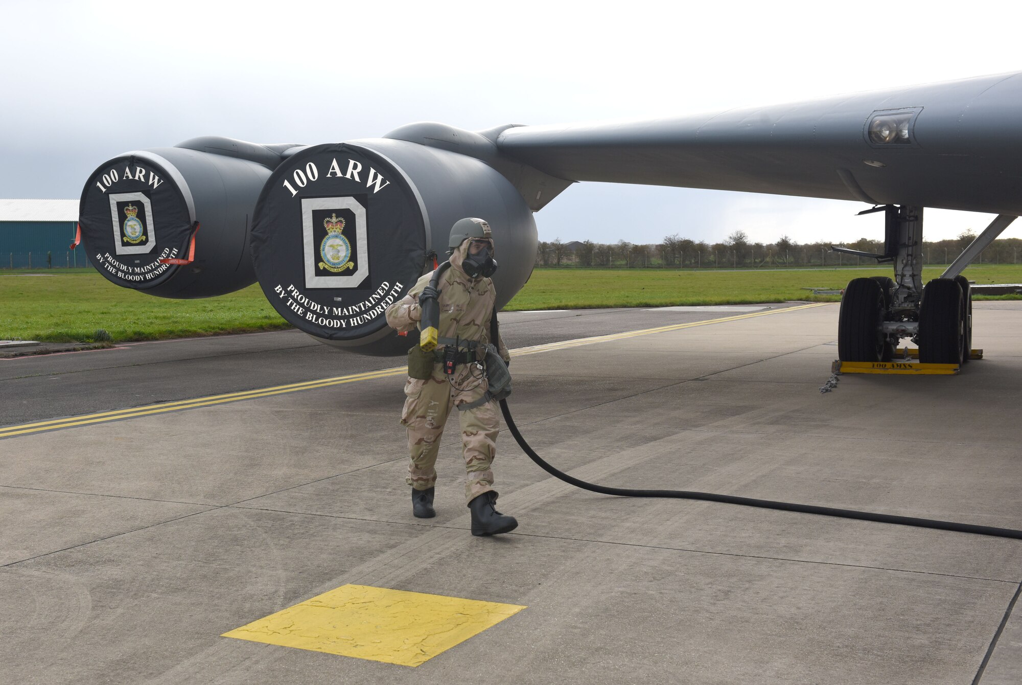 U.S. Air Force Airman 1st Class Cooper Murphy, 100th Aircraft Maintenance Squadron crew chief, prepares to connect a hose from a generator to a KC-135 Stratotanker aircraft to provide power during a chemical, biological, radiological and nuclear exercise at Royal Air Force Mildenhall, England, Oct. 28, 2020. Murphy and another crew chief were testing an innovative headset, which uses the bones in the user’s ear to transmit sound waves, to test its capabilities while being worn with Mission Oriented Protective Posture gear and ensure they could communicate with aircrew while in the aircraft. (U.S. Air Force photo by Karen Abeyasekere)