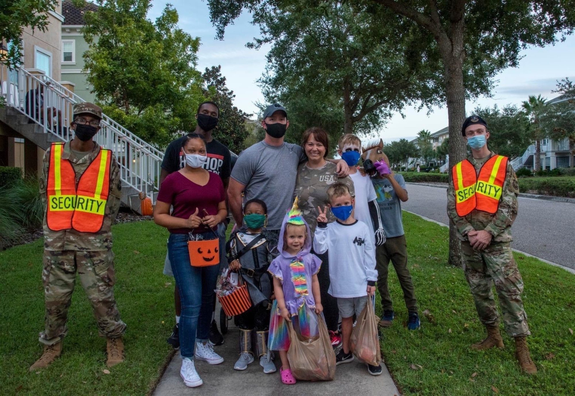 Family members and 6th Security Forces Squadron pumpkin patrol volunteers pause for a photo during trick-or-treating at Harbor Bay housing MacDill Air Force Base, Florida Oct. 31, 2020. (U.S. Air Force photo)