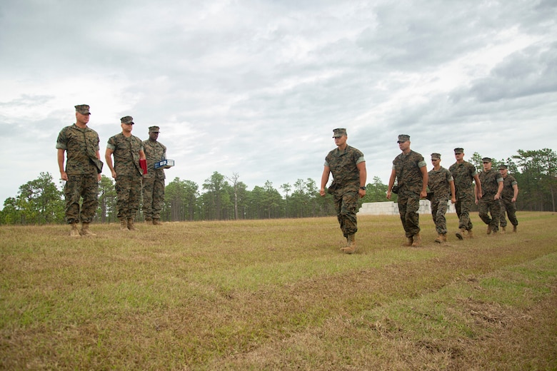 U.S. Marines with 2nd Combat Engineer Battalion and 8th Engineer Support Battalion report to Maj. Gen. Julian D. Alford, left, commanding general, Marine Corps Installations East-Marine Corps Base Camp Lejeune, during an awards ceremony at the site of the G-36 Company Battle Course Range on MCB Camp Lejeune, North Carolina, Oct. 29, 2020. Alford awarded the Marines with the Navy and Marine Corps Commendation Medal for their efforts in helping to building the range. G-36 has been redesigned to enable company commanders to train with organic weapons systems and attachments they would have available during combat and conduct full-scale operations on one range. (U.S. Marine Corps photo by Cpl. Ginnie Lee)