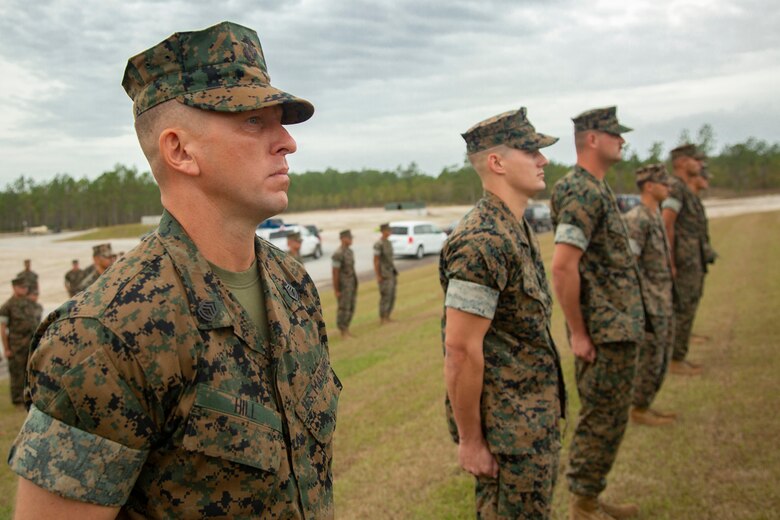 U.S. Marine Corps Gunnery Sgt. Jonathan E. Hill, left, heavy equipment chief with 2nd Combat Engineer Battalion on Marine Corps Base Camp Lejeune, stands at attention during an awards ceremony on MCB Camp Lejeune, North Carolina, Oct. 29, 2020. Hill received the Meritorious Service Medal for his efforts in building the G-36 Company Battle Course Range. G-36 has been redesigned to enable company commanders to train with organic weapons systems and attachments they would have available during combat and conduct full-scale operations on one range. (U.S. Marine Corps photo by Cpl. Ginnie Lee)