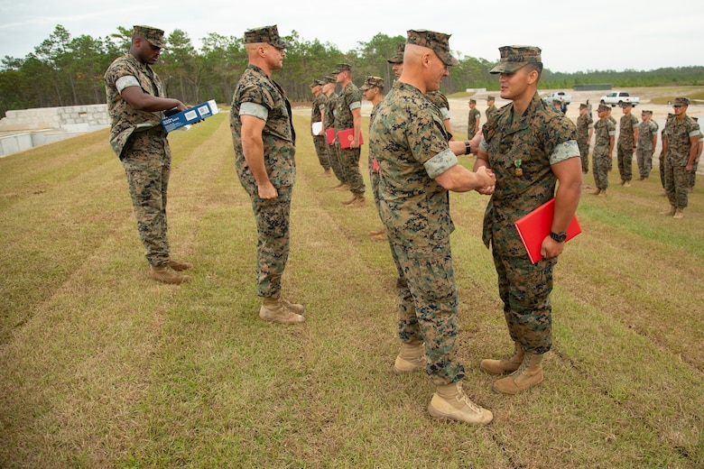 U.S. Marine Corps Maj. Gen. Julian D. Alford, left, commanding general, Marine Corps Installations East-Marine Corps Base Camp Lejeune, awards Lance Cpl. Jacob J. Morales, right, heavy equipment operator with 8th Engineer Support Battalion, MCB Camp Lejeune, the Navy and Marine Corps Commendation Medal on MCB Camp Lejeune, North Carolina, Oct. 29, 2020. Morales received the award for his efforts in building the G-36 Company Battle Course Range. G-36 has been redesigned to enable company commanders to train with organic weapons systems and attachments they would have available during combat and conduct full-scale operations on one range.  (U.S. Marine Corps photo by Cpl. Ginnie Lee)
