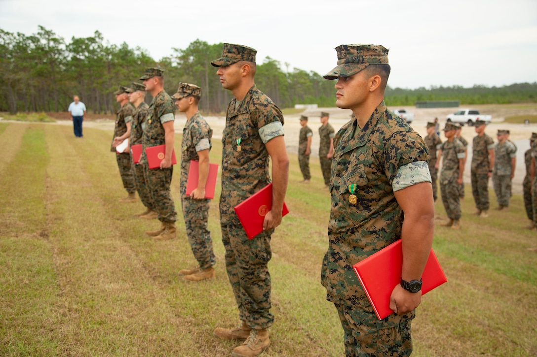 U.S. Marines with 2nd Combat Engineer Battalion and 8th Engineer Support Battalion stand at attention during an awards ceremony at the site of the G-36 Company Battle Course Range on Marine Corps Base Camp Lejeune, North Carolina, Oct. 29, 2020. Maj. Gen. Julian D. Alford, commanding general Marine Corps Installations East-Marine Corps Base Camp Lejeune, awarded the Marines the Navy and Marine Corps Commendation Medal for their efforts in building the range. G-36 has been redesigned to enable company commanders to train with organic weapons systems and attachments they would have available while forward deployed and  conduct full-scale operations on one range.  (U.S. Marine Corps photo by Cpl. Ginnie Lee)