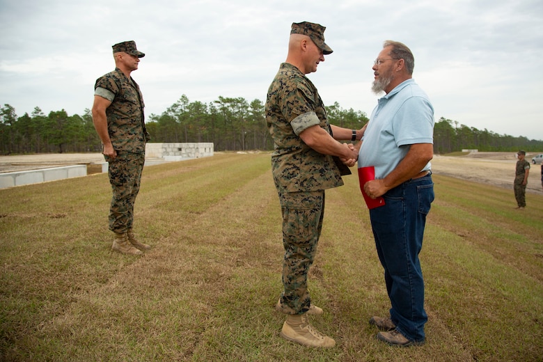 U.S. Marine Corps Maj. Gen. Julian D. Alford, left, commanding general, Marine Corps Installations East-Marine Corps Base Camp Lejeune, presents a letter of appreciation to Fredrick L. Small, the range developmental progress officer for MCB Camp Lejeune, during an awards ceremony on MCB Camp Lejeune, North Carolina, Oct. 29, 2020. Small received the letter for his efforts during the planning and transformation of the G-36 Company Battle Course Range. G-36 has been redesigned to enable company commanders to train with organic weapons systems and attachments they would have available during combat and conduct full-scale operations on one range. (U.S. Marine Corps photo by Cpl. Ginnie Lee)